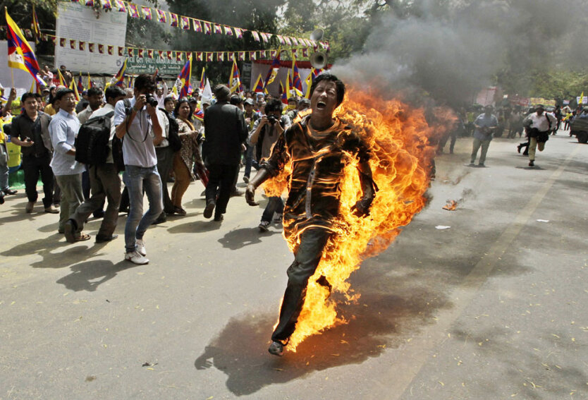 36 26 марта 2012. Нью-Дели, Индия. Попытка самосожжения тибетского активиста перед визитом в страну китайского лидера Ху Цзиньтао. (AP Photo/Manish Swarup)  