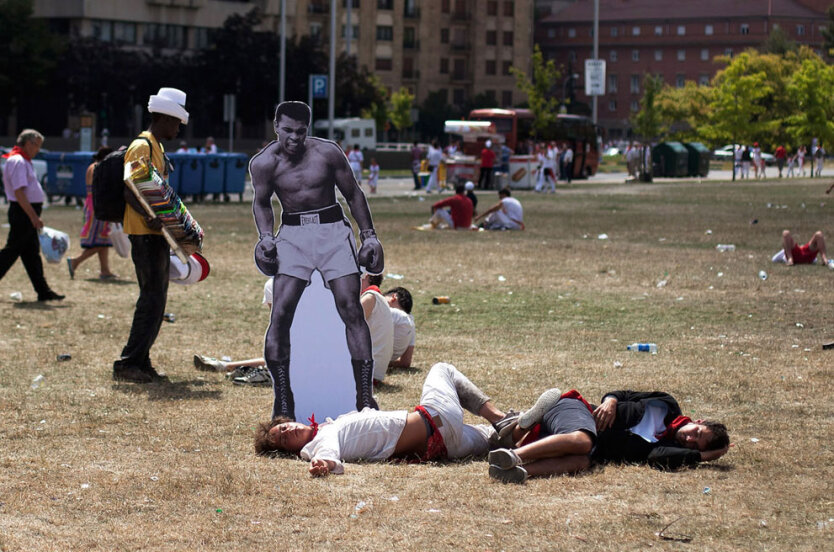 8 июля 2012. Испания. Картонная фигура Мохаммеда Али, поставленная уличными художниками рядом со спящими мужчинами в парке