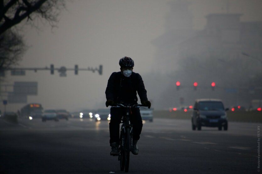 A cyclist wears a face mask on a polluted day in Beijing