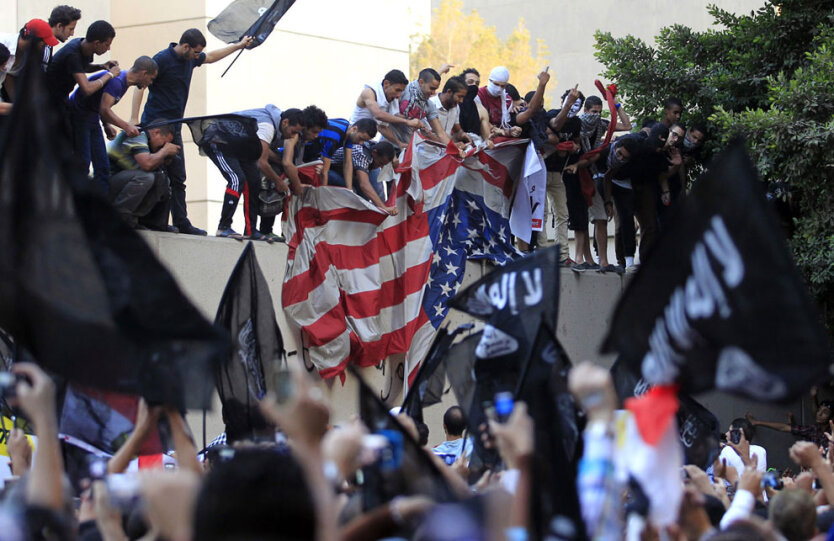 11 сентября 2012. Египет. Протестующие срывают американский флаг с посольства США в Каире. 