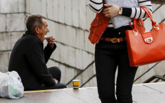 A man eats his sandwich as he begs money near an underground passage in Kiev