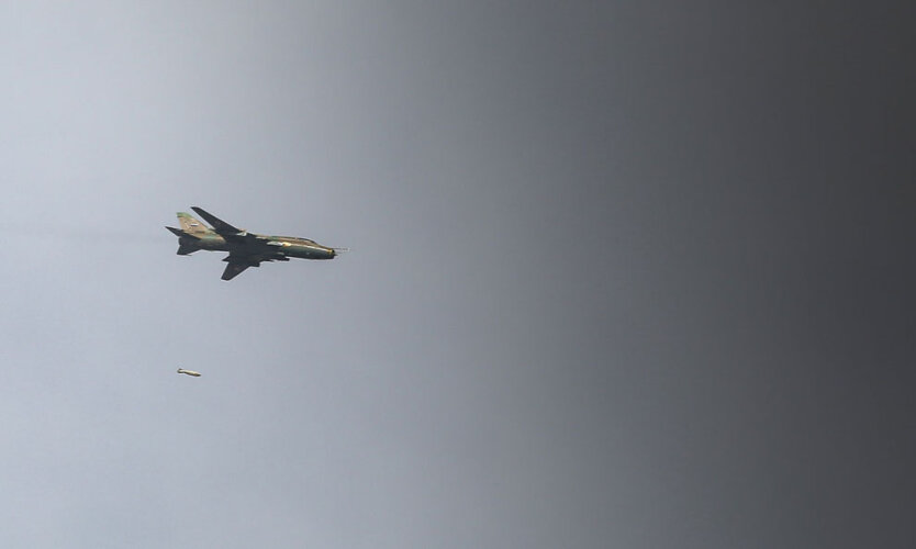 Правительственный истребитель-бомбардировщик Су-17 сбрасывает 500-фунтовую авиабомбу над городом Мааррет-эн-Нууман.