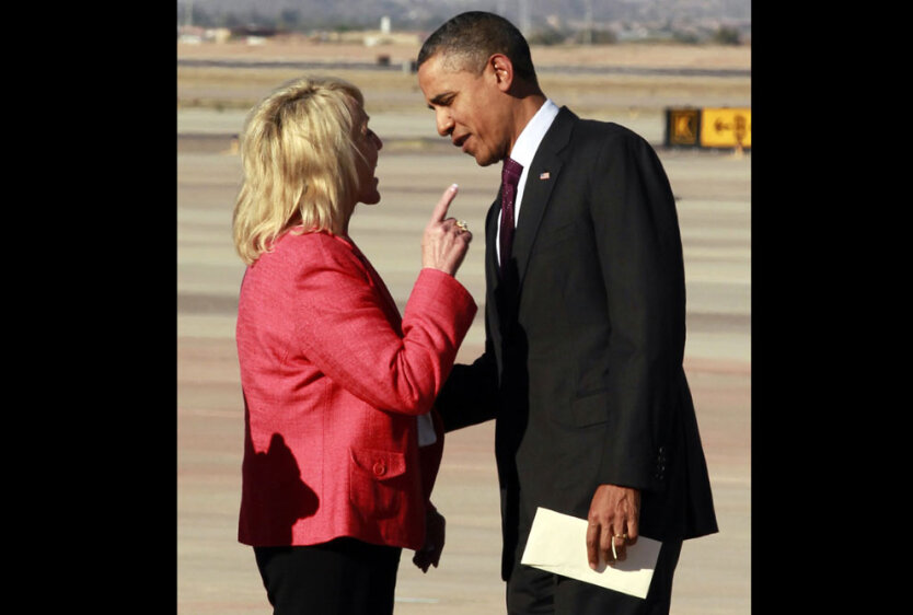 Аризонская губернатор-республиканец Яна Брюэр оживленно жестикулирует во время разговора с президентом США Бараком Обамой после его прибытия в аэропорт Феникс-Меса, в городе Меса, штат Аризона. 