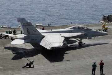 A F/A-18E/F Super Hornets of Strike Fighter Attack Squadron 211 (VFA-211) is lined up for take off on the flight deck of the USS Theodore Roosevelt (CVN-71) aircraft carrier in the Gulf