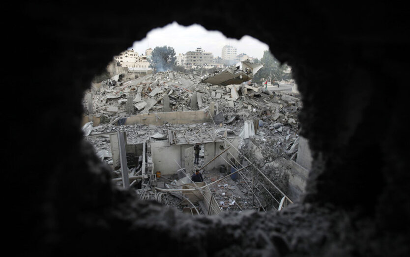 Палестинцы осматривают  разрушенное административное  здание  премьер-министра Исмаила Хании в городе Газа, 17 ноября 2012 года.