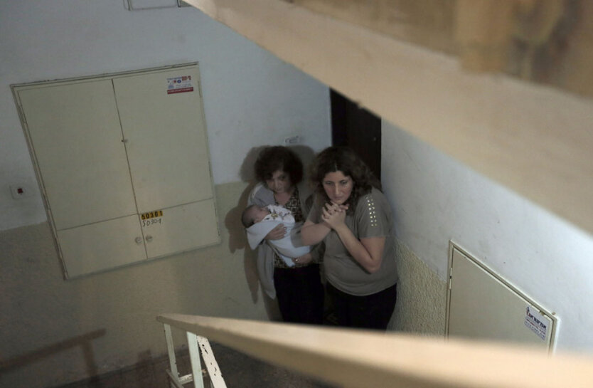 Израильские женщины укрылись на лестничной клетке во время воздушной тревоги в прибрежном городе Ашкелон,