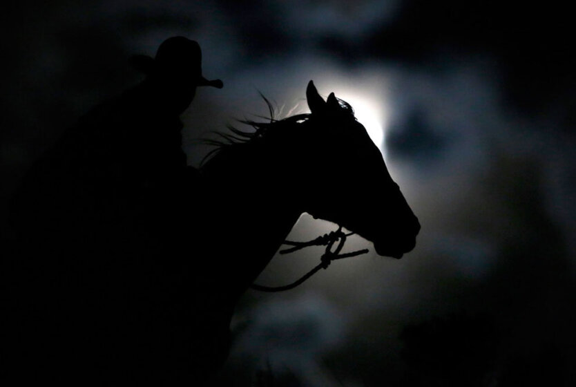 Ковбой Нейт Камминс едет верхом лунной ночью, штат Монтана