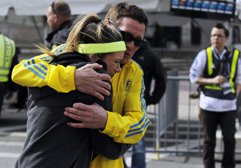 Мужчина успокаивает женщину, шокированную последствиями взрывов во время проведения 117-го Бостонского марафона, город Бостон, штат Массачусетс, понедельник, 15 апреля 2013 года. (Reuters/Jessica Rinaldi)  