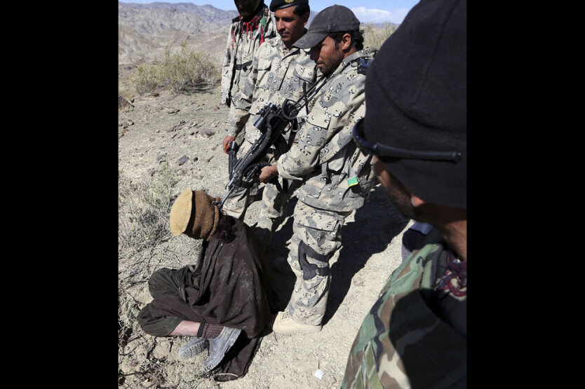 Провинция Пактика. Афганский пограничник целится в голову предполагаемого талибского боевика, позируя для фотографии