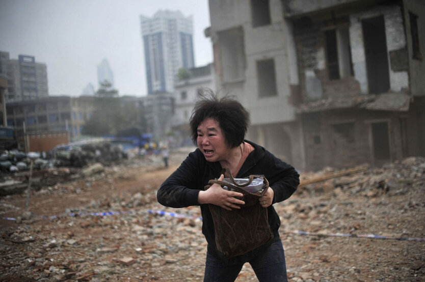 Реакция Хуань Суфэнь, жительницы деревни Янгжи, на разрушение её дома рабочими, провинция Гуаньдун, Китай. 