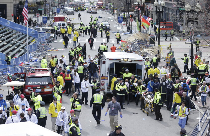 Медики оказывают помощь пострадавшим от взрыва во время проведения Бостонского марафона в понедельник, 15 апреля 2013 года. (AP Photo/Charles Krupa)