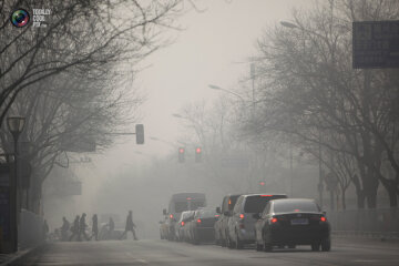1. Центр Пекина зимой. Люди идут по задымленной улице. (Jason Lee / Reuters)