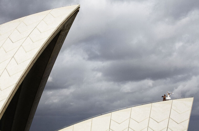 Известная артистка австралийского балета Амбер Скотт (справа) и артист театра танца Бангарра Патрик Тэйдей во время фотоснимка на крыше Сиднейского оперного театра в честь празднования 50-го юбилея открытия балета. 