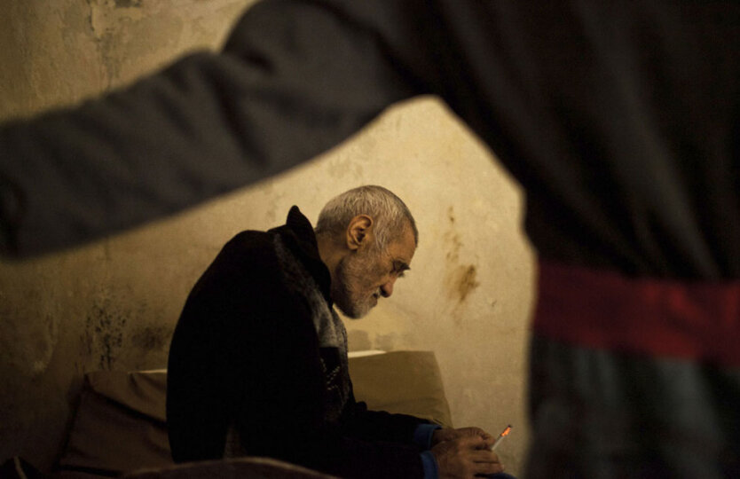 Мужчина курит в помещении психиатрической больницы Алеппо.