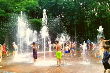 Киевляне спасаются от летней жары в фонтанах. Играют дети