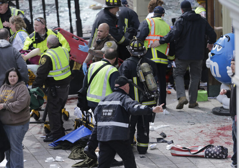 Медицинские рабтники оказывают помощь пострадавшим от взрыва во время проведения Бостонского марафона в понедельник, 15 апреля 2013 года в городе Бостон, штат Массачусетс. (AP Photo/Charles Krupa)  