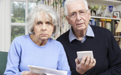 Senior Couple At Home With Bills Worried About Home Finances