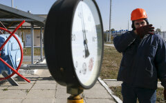 A worker stands near a pressure gauge and a valve at a gas compressor station and underground gas storage facility in the village of Mryn