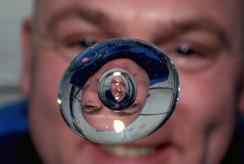 Международная космическая станция, околоземная орбита. Космонавт Андре Кёйперс смотрит на пузырек воздуха в капле воды наслаждаясь последними днями невесомости перед возвращением на Землю. 
