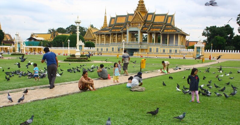 площадь возле королевского дворца, Пном Пень, Камбоджа. Люди кормят голубей