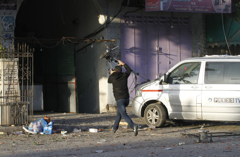 Журналисты из различных СМИ бегут после удара израильской авиации по телеканалу