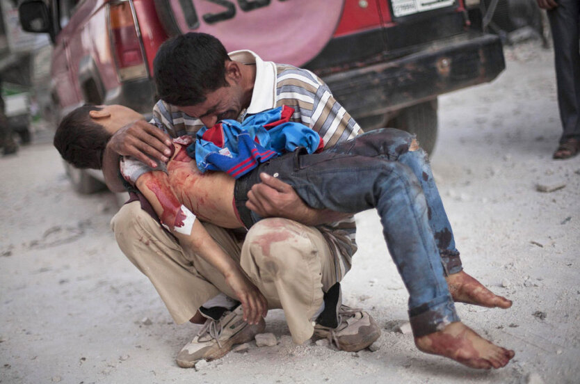 Госпиталь Дар-ель-Шифа в Алеппо, Сирия. Мужчина плачет над телом своего сына, погибшего, когда три террориста-смертника подорвали себя в автомобилях