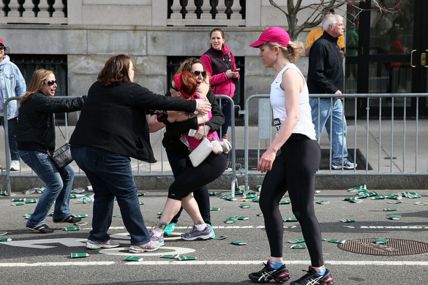 Бегунью утешает незнакомая женщина. Район площади Кенмор в городе Бостон. Недалеко отсюда прогремели взрывы. (Alex Trautwig/Getty Images)  