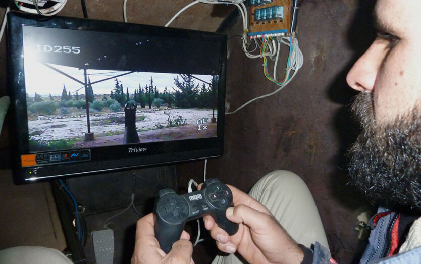Повстанец при помощи джойстика для компьютерных видеоигр управляет пулемётом, установленным на крыше бронеавтомобиля «Шам-2». 