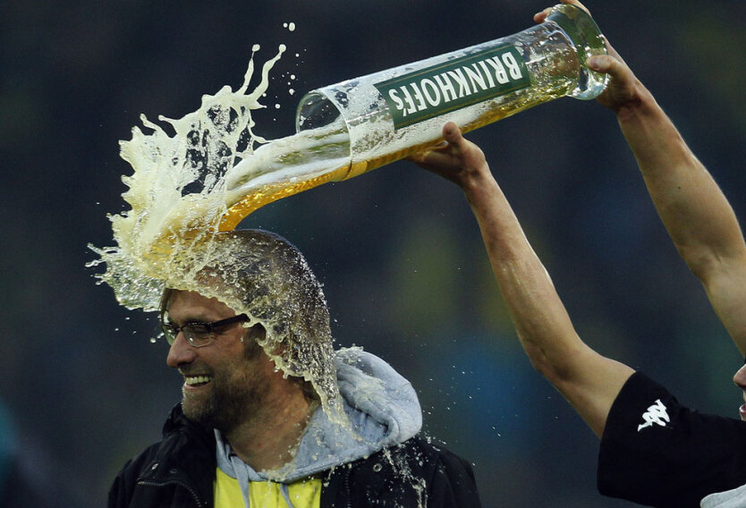 Игрок дортмундской «Боруссии» Лукаш Пищек льет пиво на голову своему тренеру Юргену Клоппу после победы в игре. 