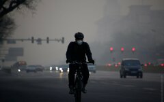 A cyclist wears a face mask on a polluted day in Beijing