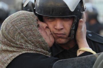 Участница антиправительственной демонстрации в Египте целует полицейского. Фото: Lefteris Pitarakis / AP via MSN с сайта metkere.com