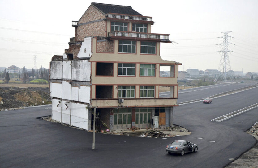 Автомобиль останавливается возле жилого дома посреди недавно построенной магистрали в провинции Чжэцзян