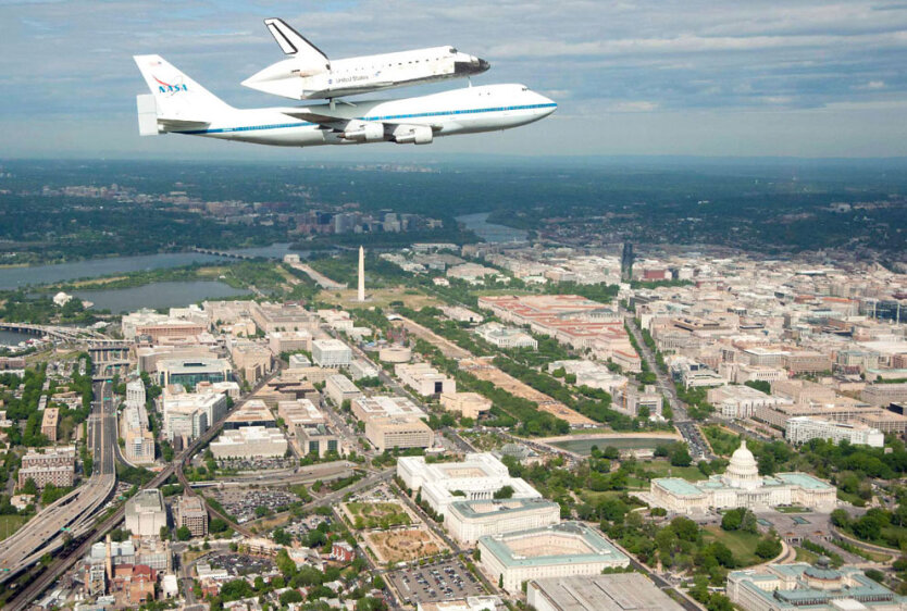 Небо над Вашингтоном, округ Колумбия, США. После последнего полета на околоземную орбиту в марте 2011 года шаттл Discovery самолетом  Boeing-747 доставляется в Национальный музей авиации и космонавтики Смитсоновского института. 