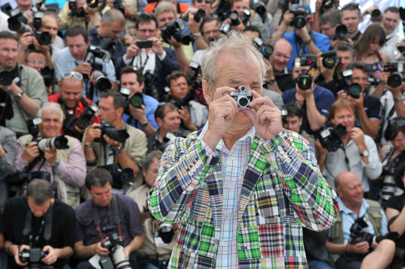 Актер Билл Мюррей фотографируется с фотоаппаратом на фоне группы фотографов после показа фильма «Королевство полной луны» на 65-м кинофестивале в Каннах