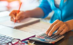 woman working with calculator, business document and laptop computer notebook