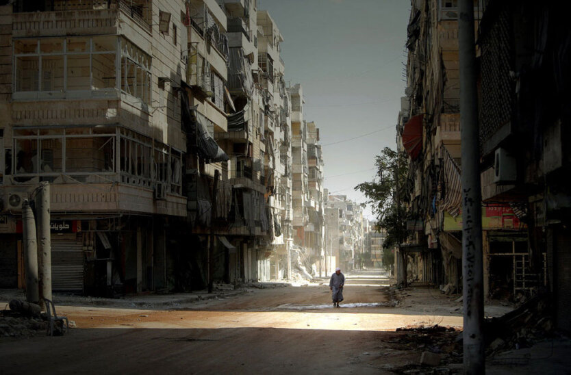 Сириец идет по разрушенному войной району Салахаддин в городе Алеппо. 