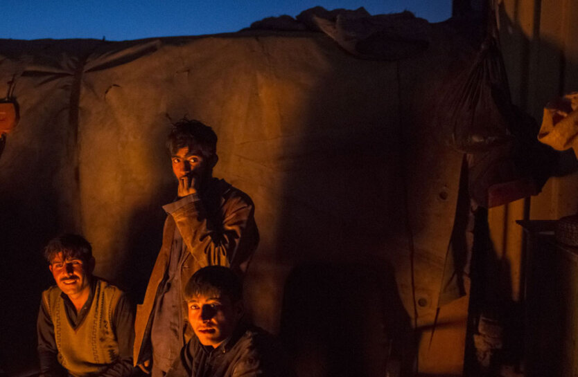 14 ноября 2012. Молодые афганцы-пуштуны греются возле костра на свалке в Кабуле. 