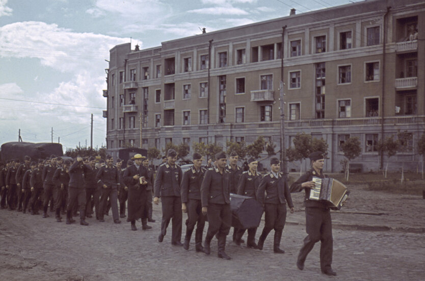 Харьков во время фашистской оккупации. Немецкие солдаты маршируют, распевая песни под гармошку по улицам Харькова