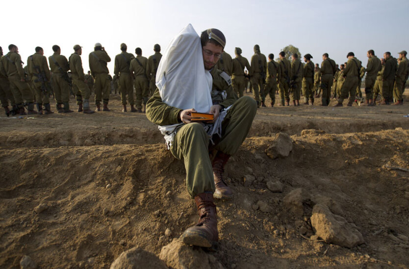  Израильский офицер держит свиток Торы. 19 ноября 2012 года.