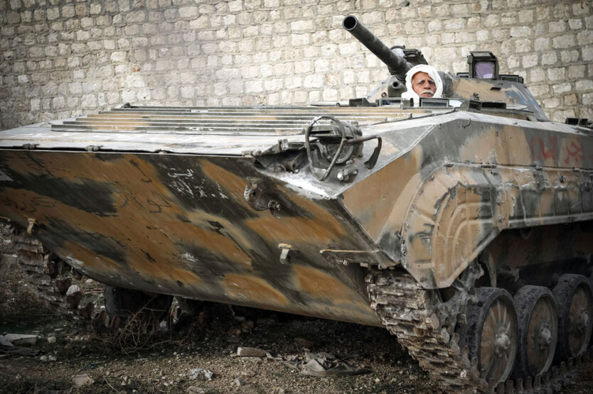 17 ноября 2012. 58-летний Абу Файез, прослуживший офицером в сирийской армии с 1970 по 2002 год, управляет БМП во время боевой операции Свободной армии Сирии против правительственных войск в окрестностях города Маарет-эн-Нууман