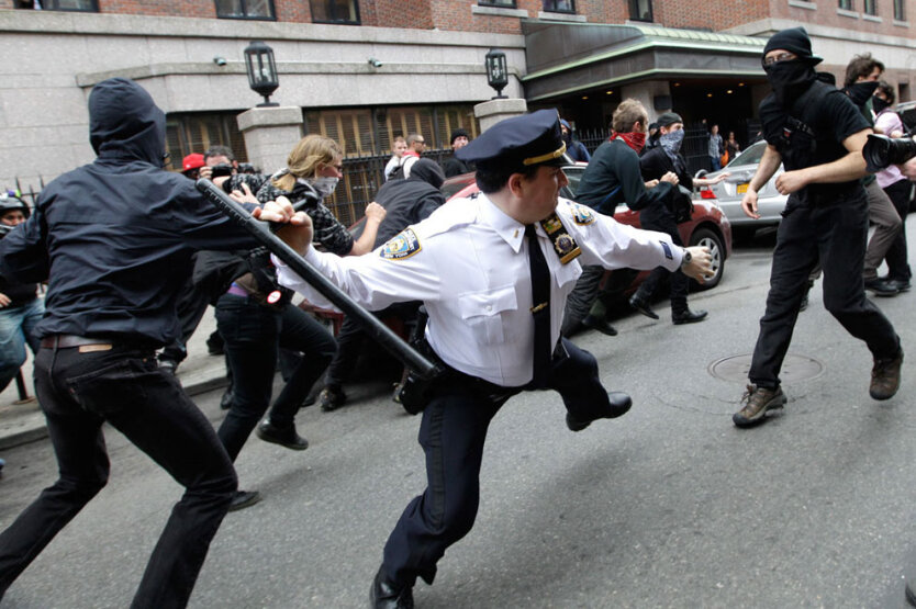 Полицейский замахивается дубинкой на активиста движения Occupy Wall Street, вышедшего на первомайскую демонстрацию. 